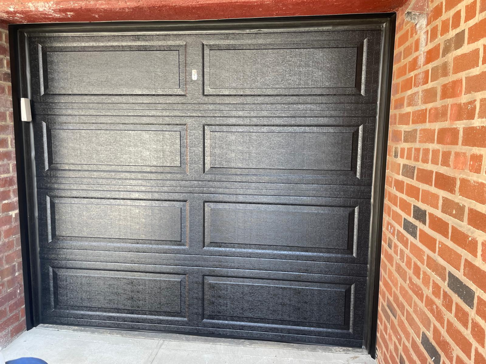 Textured black steel garage door installation