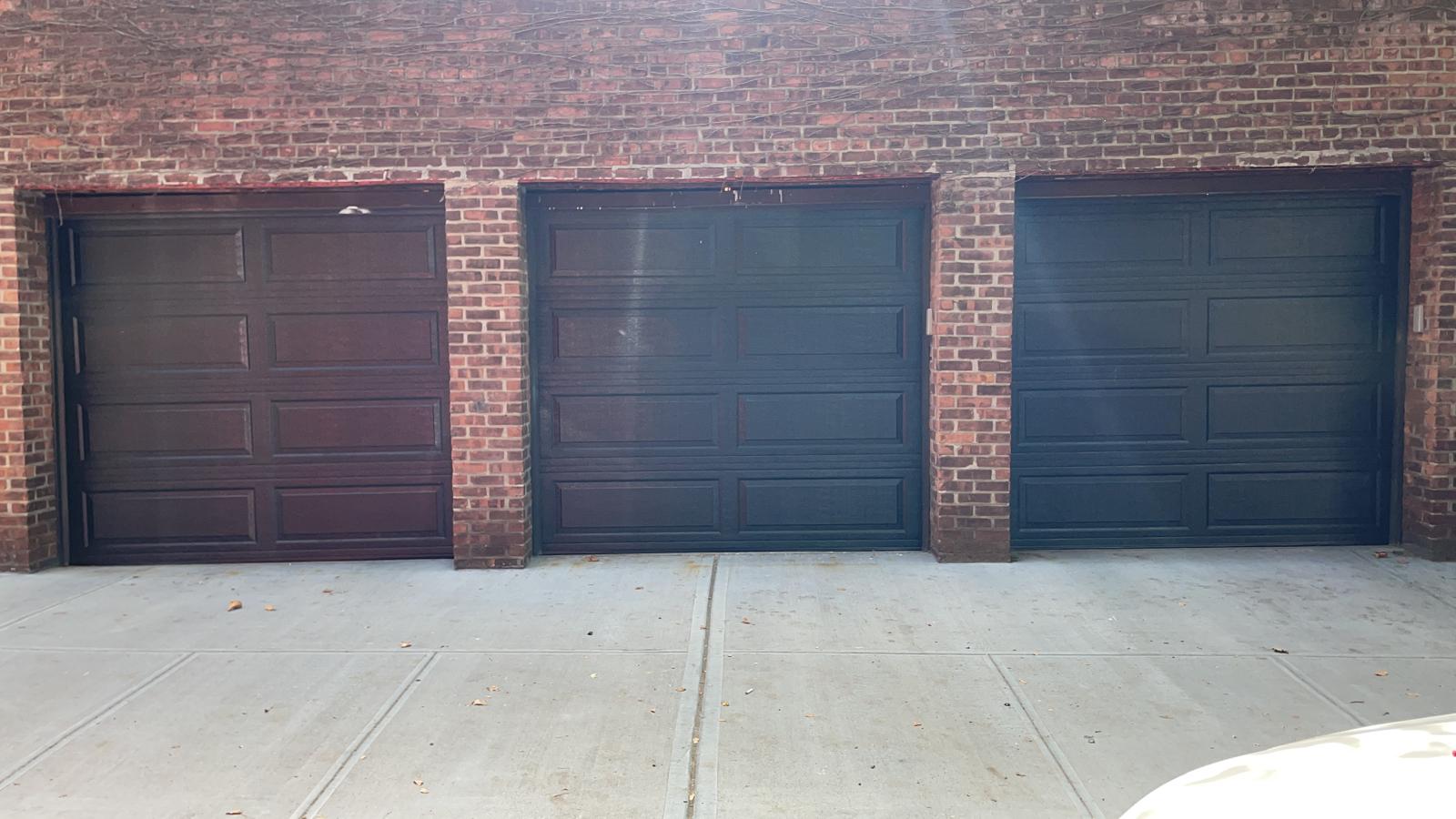 Three-bay garage door installation on a brick building